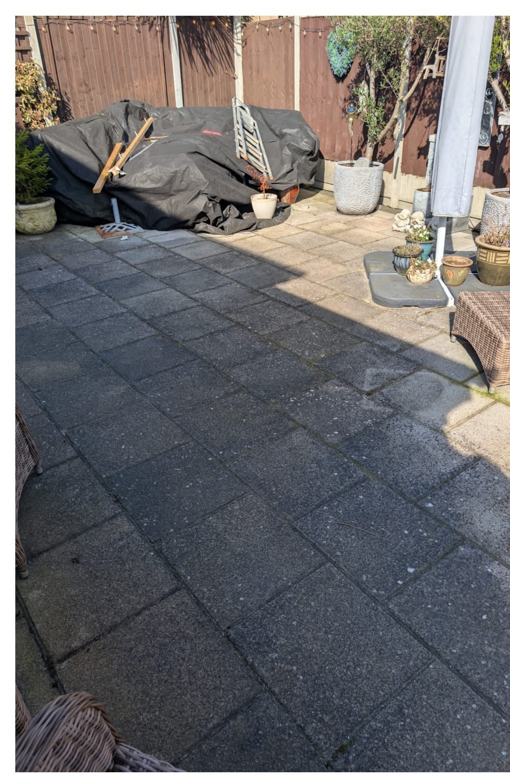 Garden patio before pressure washing - blackened slabs